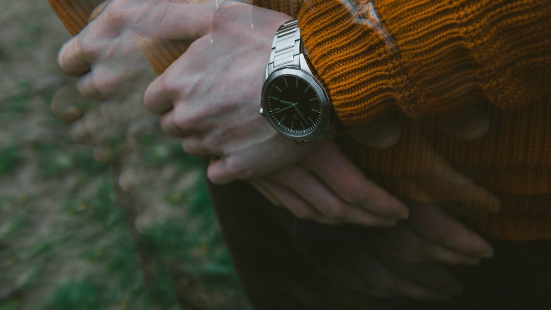 Elegant dress watch on wooden background with leather strap